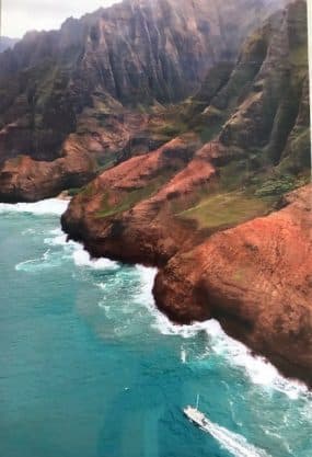 Photo of coast line, red rolling rocks of a Hawaiian island.