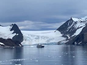 Cruise ship infront of a iceberg and mountains