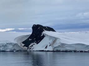 Hope Bay with mountains in background. Small icebergs in water.